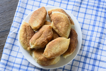 Baked pies on a plate on a kitchen towel