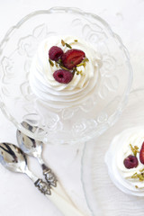 Pavlova cakes with cream and fresh summer berries