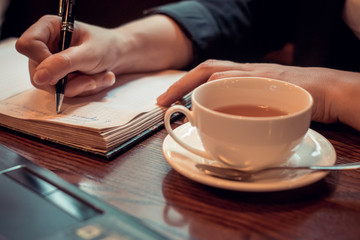 a young woman works in a coffee shop with Notepad