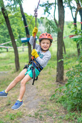 A little happy and smiling rock climber tie a knot on a rope. A person is preparing for the ascent. The child learns to tie a knot. Checking the insurance for climbing.
