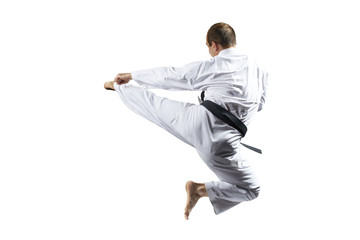 In karategi, an athlete beats a kick in jump against a white background isolated