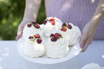 Pavlova cakes with cream and fresh summer berries