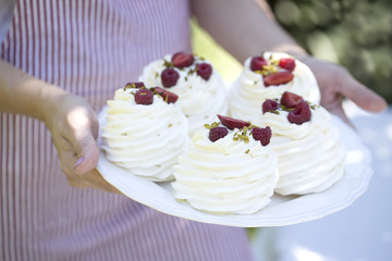 Pavlova cakes with cream and fresh summer berries