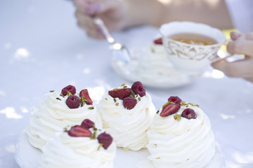 Pavlova cakes with cream and fresh summer berries