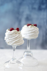 Pavlova cakes with cream and fresh summer berries