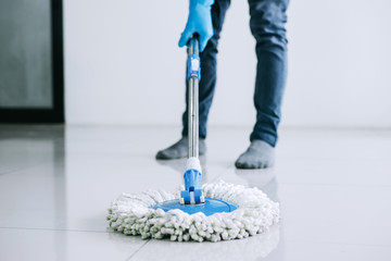 Husband housekeeping and cleaning concept, Happy young man in blue rubber gloves wiping dust using...