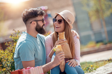 Fototapeta premium Couple in park eating a sandwiches
