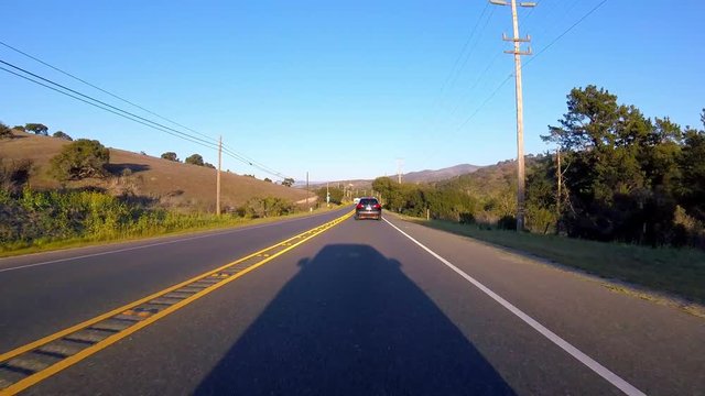 Driving down highway with only shadow of car being seen