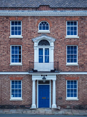 Fototapeta na wymiar Old European brick facade with windows and colmns in a symmetrical style