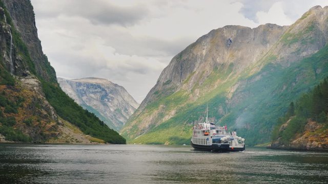 A small cruise ship with tourists begins a trip to the fjord in Norway