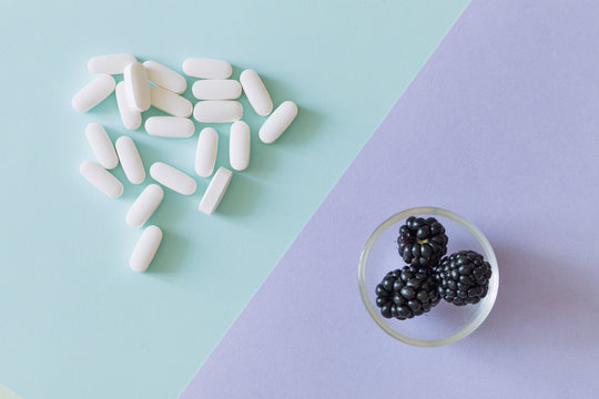 Medical pills and fresh, healthy fruit a source of natural vitamins