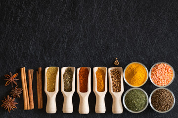 Herbs, spices and food additives on a dark background with an empty place