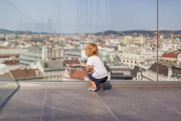 Fototapeta na wymiar Girl looks at the city. Little child looking on skyline. Kleines Kind schaut auf Stadt. 
