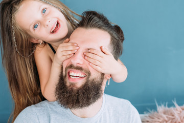 playful family leisure. daughter's love expression. little girl covering daddy's eyes from behind....