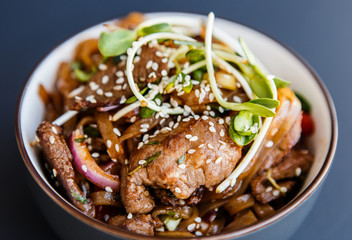 A plate ofwok beef noodles on the dark background