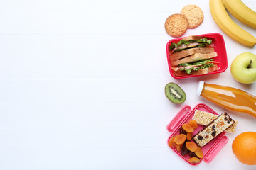 Fototapeta na wymiar School lunch box with sandwich and fruits on wooden table