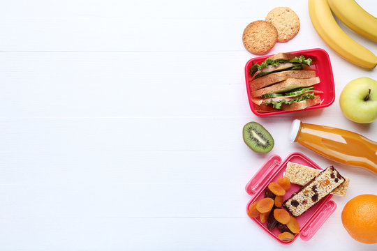 School lunch box with sandwich and fruits on wooden table