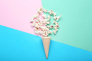Popcorn with waffle cone on colorful background