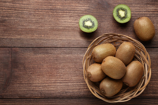 Kiwi fruits in basket on brown wooden table