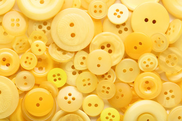 Yellow sewing buttons on white background