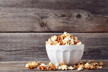 Caramel popcorn in bowl on wooden table