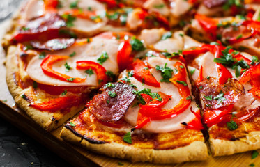 slices of Pizza with Mozzarella cheese, Ham, Tomatoes, salami, pepper, pepperoni Spices and Fresh Basil. Italian pizza