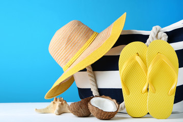 Summer bag with flip flops and coconuts on blue background