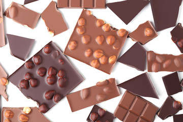Chocolate pieces and hazelnuts on white background