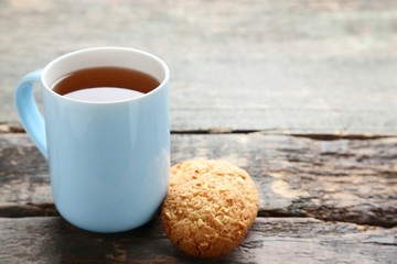 Cup of tea with cookies on grey wooden table