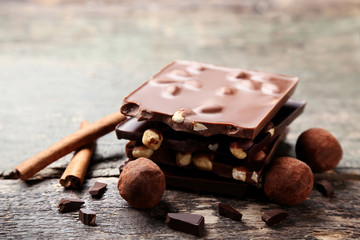 Chocolate pieces with nuts and candy balls on wooden table