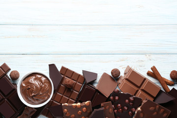 Chocolate pieces with nuts and cocoa balls on wooden table