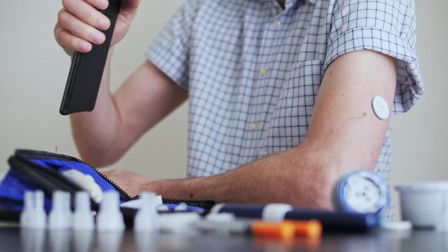 A man hands brings to the hand the smartphone for measuring glucose in the blood