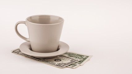 Empty cup of coffee with dollars on white background © kaninstudio