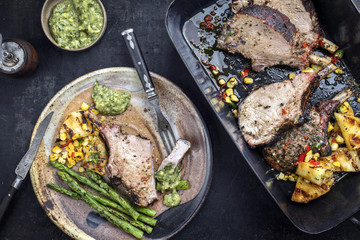 Exotically barbecue veal back racks carree roast with green asaparagus and pineapple as top view in a backing dish
