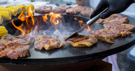 Grillparty BBQ mit Lachs Fleisch und Mais auf dem offenen Grill mit Flamme
