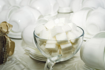 Fototapeta na wymiar refined sugar in glass sugar and clean tea cups.