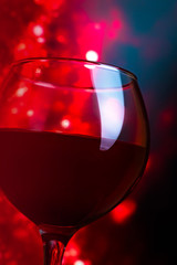 Glass with red wine on a dark red background