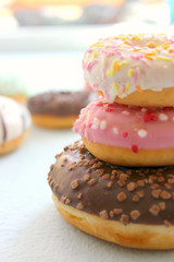 Photos of different donuts. Assorted colorful donuts in pink, green, chocolate icing close-up, sweet dessert.