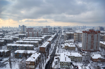 The aerial View of residential district in Kyiv,Ukraine in cloudy winter day.View over the city rooftops with sunlight and snow.Moderns buildings at Industrial uptown, residential neighbourhood