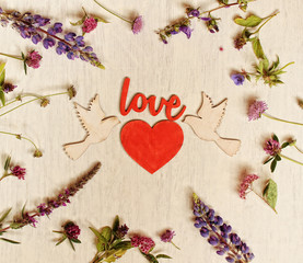 Fototapeta na wymiar love ,anniversary, birthday,mother's day card with wooden heart and summer meadow flowers /inscription 'love'