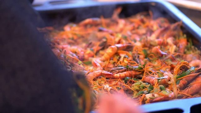 Cooking seasoned shrimp for chipotle shrimp tacos. Shrimp with parsley and lime in a frying pan cook mixes, closeup
