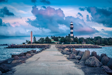 Lighthouse at the entrance to the port of Riga in the evening, in August after sunset - obrazy, fototapety, plakaty