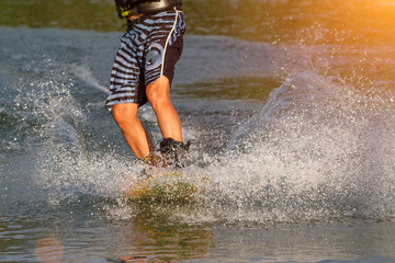 a man engaged in wakeboard on the lake performs jumps