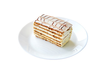 Sweets, cake, traditional hungarian,austrian cuisine. Esterhazy cake sliced on white background. Sweet tasty dessert on white round plate close-up served. Isolated on white background.