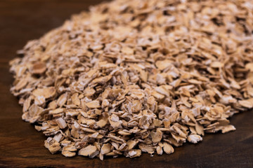 Oat flakes close up on wooden background.