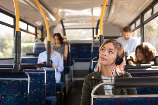 Woman listening music while travelling in modern bus