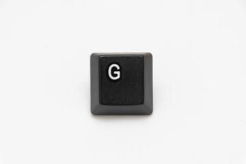 Single black keys of keyboard with different letters G