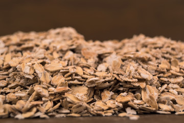 Scattered on the table oat flakes, close-up with a shallow depth of field.