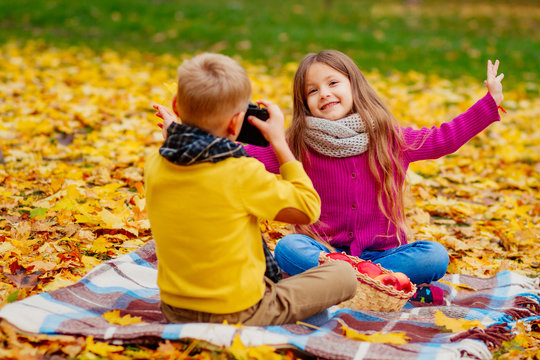 children's friendship, children play in nature in the fall, the boy takes pictures