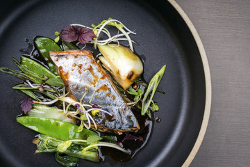Modern style Japanese bonito tuna fish filet with vegetable glazed in teriyaki sauce as top view on...